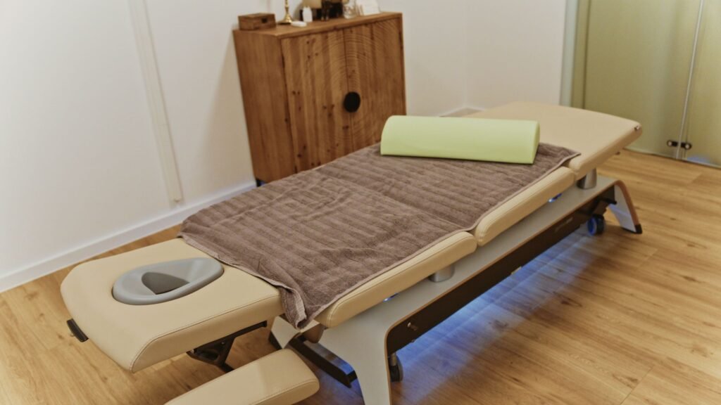 Heller Behandlungsraum mit elektrischer Therapieliege
