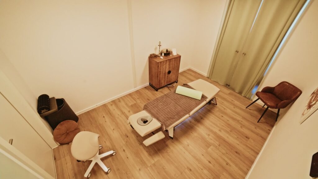 Behandlungsraum mit Liege, Hocker und Sessel
